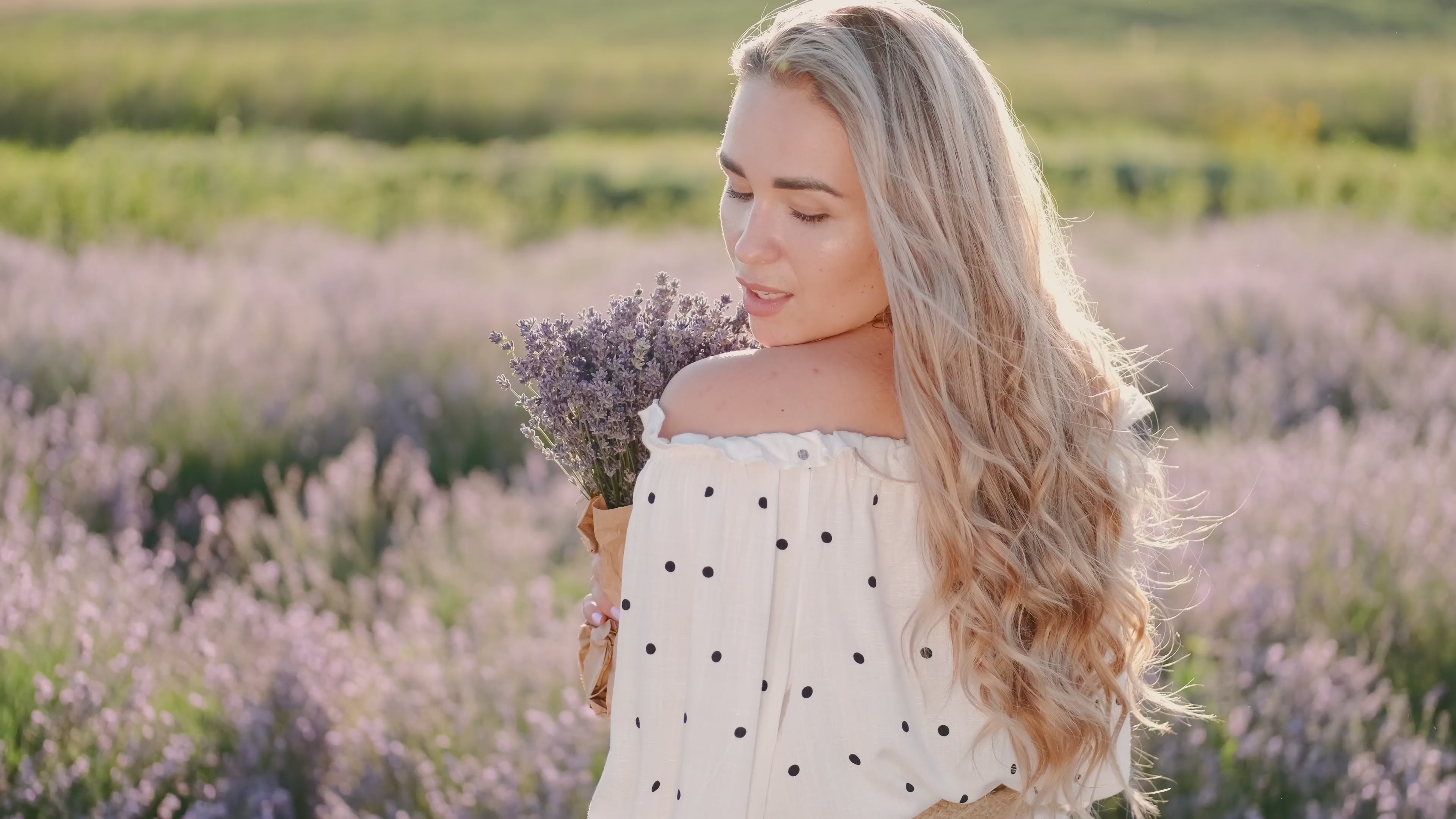 Woman in white off-shoulder dress holding lavender bouquet in blooming lavender field — Emmy & Ellie women's fashion